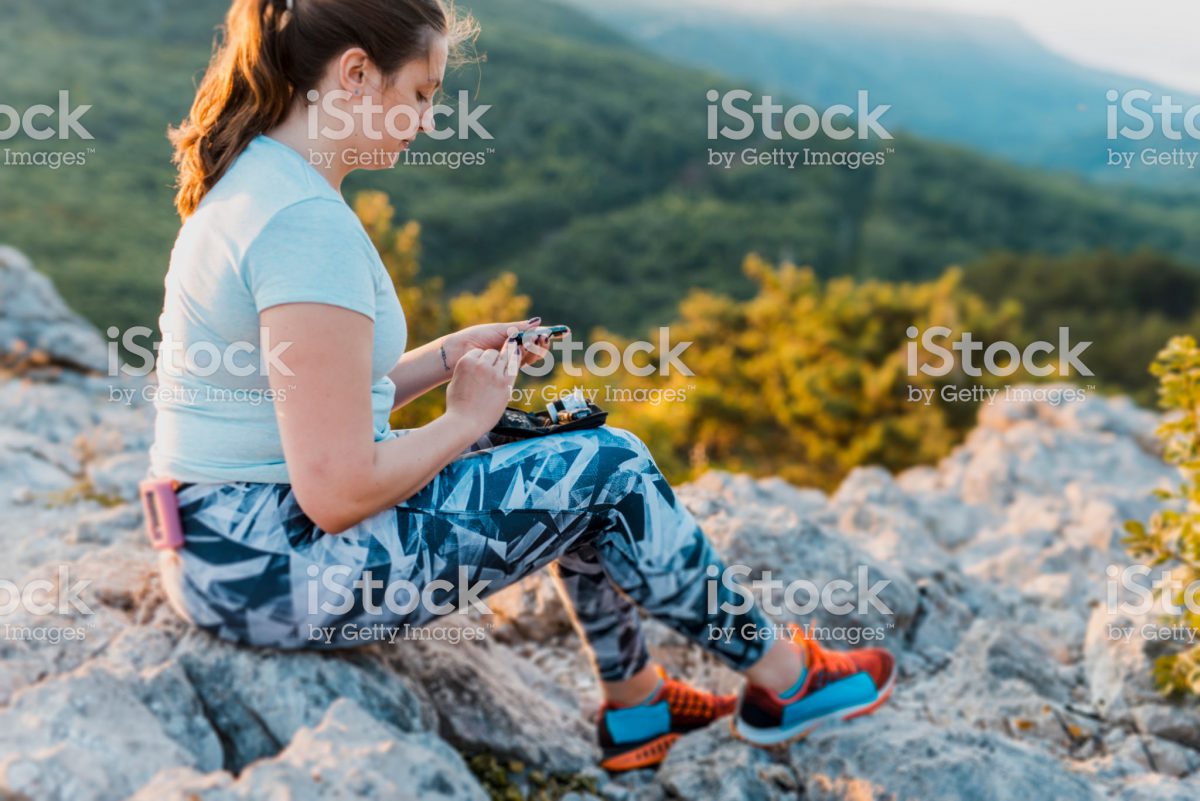 Photo of a woman on a hike testing her blood sugar
